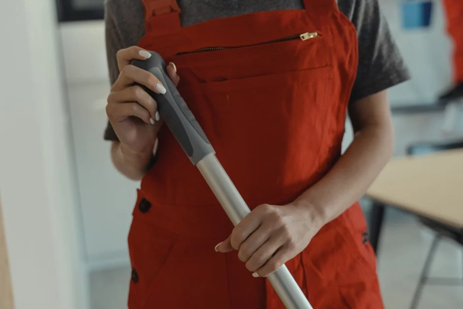 Person using spray bottle and cloth for cleaning a kitchen shelf, ensuring hygiene and cleanliness.