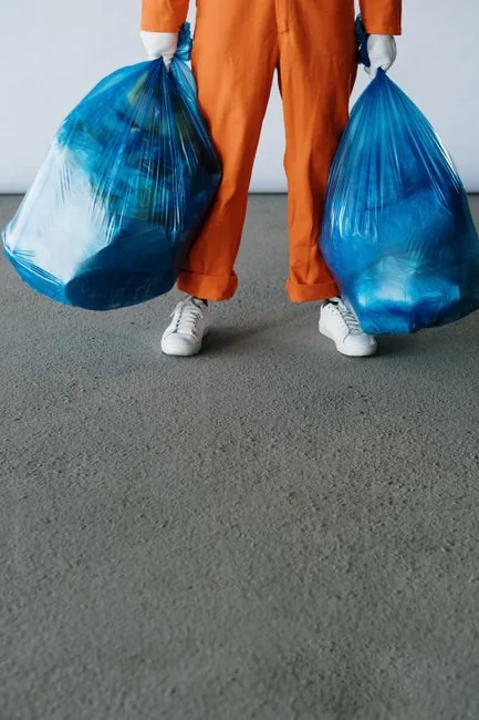 Asian woman cleaning a messy living room at home with a vacuum cleaner, creating a tidy space.